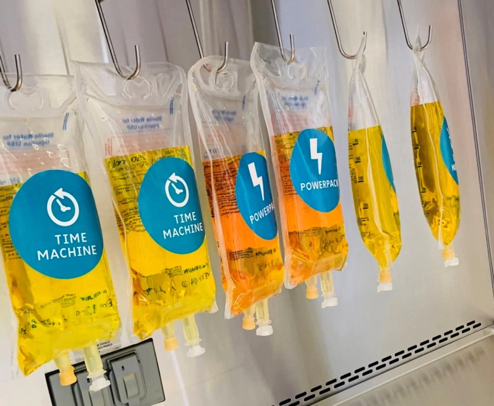 row of IV bags hanging from hooks